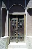 Tradiční dveře ve městě Kashan. Můžete vidět dva druhy dveřních klepadel - jeden pro muže a druhý pro ženy. Každý vydává jiný zvuk. Pomocí toho se dá poznat, kdo má jít otevřít. Můžům otevírá dveře muž a ženám žena. Írán.