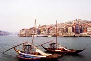 Lodě převážejí sudy s portským vínem, Porto. Portugalsko.