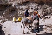 Domorodci chodí pro vodu vynášenou řetězcem mužů z cca 20m hluboké studny. Zpívající studny v Dublocku. Etiopie.