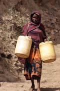 Domorodci chodí pro vodu vynášenou řetězcem mužů z cca 20m hluboké studny,Zpívající studny v Dublocku. Etiopie.