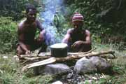 Průvodci vaří oběd během treku. Papua,  Indonésie.