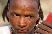 Muž z kočovného etnika Wodaabé (nazýváni též Bororo) se líčí na tanec Yaake. Slavnost Gerewol. Niger.