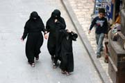 Ženy v tradičním černém oblečení na ulici v hlavním města Sana. Jemen.